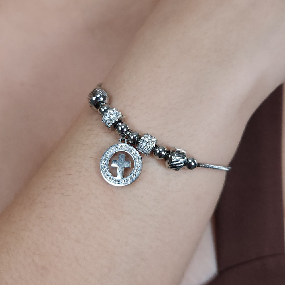 Pulseira bolas prateada e cravejada com pingente cruz detalhe vazado