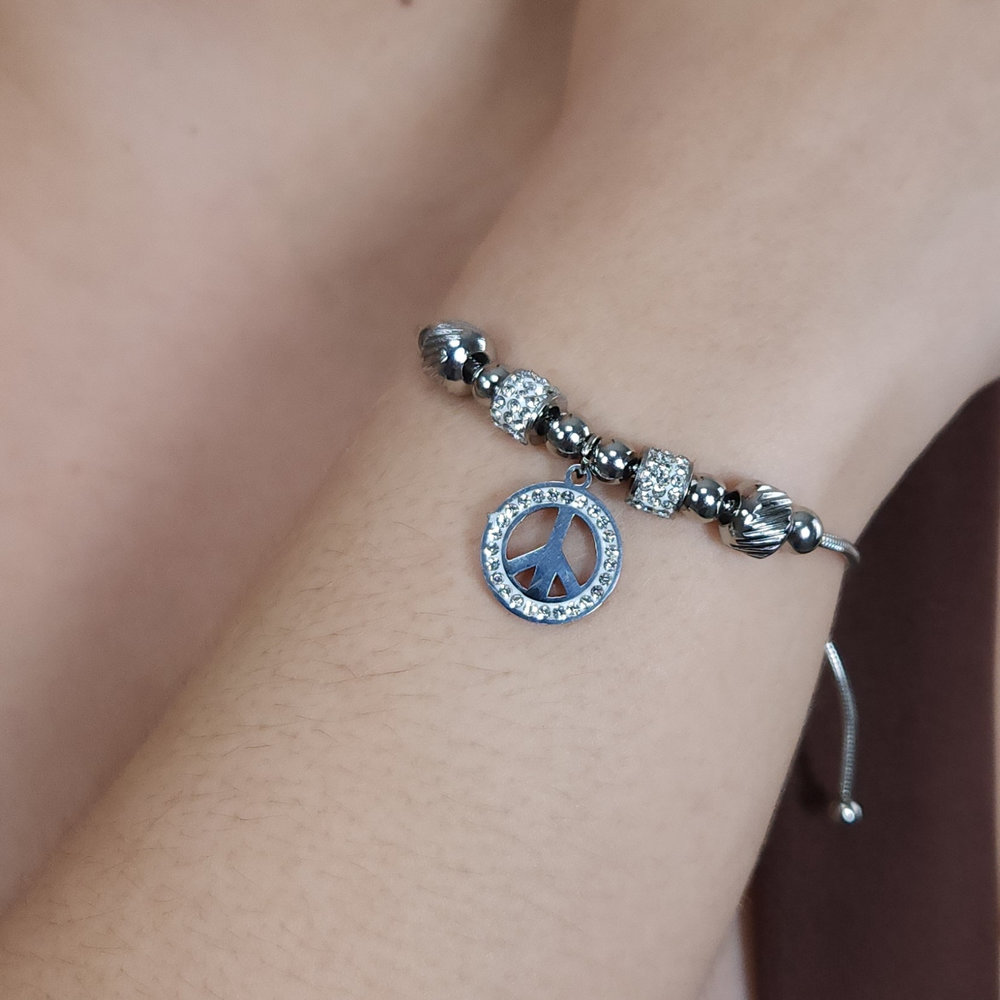 Pulseira bolas prateada e cravejada com pingente símbolo da paz