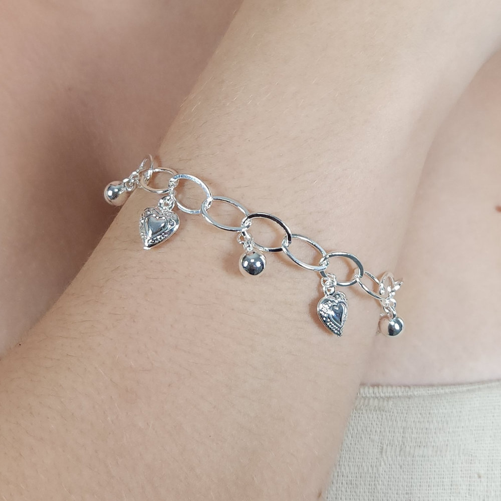 Pulsira elo oval com coração detalhado e bolinhas lisas