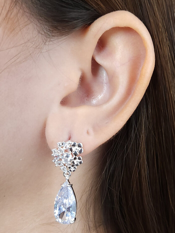 Brinco celebre cravejado com flores detalhe pêndulo cristal